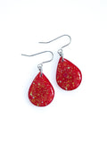 Clio drop earrings in red with iridescent colour shifting glitter on a white background