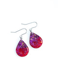 Clio drop earrings in red with purple and gold holographic colour shifting glitter on a white background