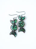 Hecate triple moon drop earrings in transparent black with iridescent glitter on a white background