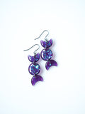 Hecate triple moon drop earrings in transparent purple with iridescent glitter on a white background
