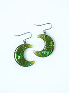 Luna moon drop earrings in green iridescent glitter on a white background
