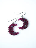 Luna moon drop earrings in transparent purple with iridescent glitter on a white background