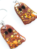Close up of Melinoë ghost drop earrings in autumn brown with gold holographic colour shifting glitter on a white background
