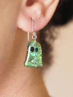A pair of Melinoe ghost drop earrings, shown being worn. The wearers face is out of shot with hair pulled back to display the earring. 
