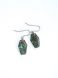 Morrigan coffin earrings in transparent black with iridescent colour shifting glitter on a white background