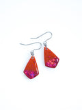 Persephone drop earrings in orange with pink holographic colour shifting glitter on a white background