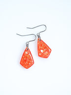 Persephone drop earrings in orange with iridescent colour shifting glitter on a white background