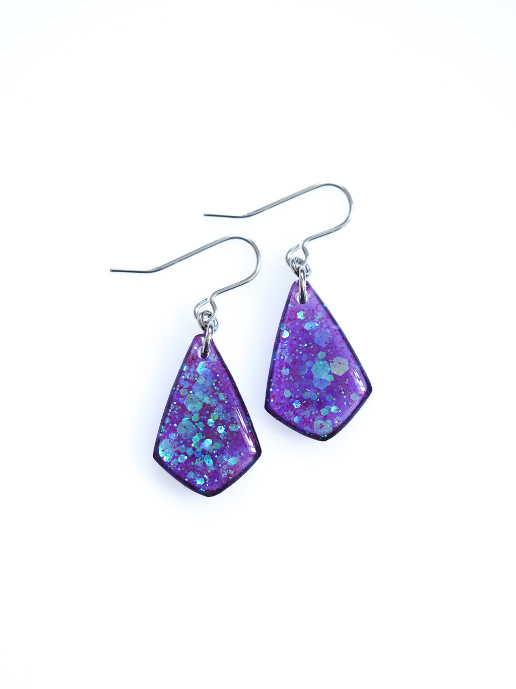 Persephone drop earrings in purple with iridescent colour shifting glitter on a white background