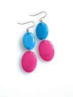 Duet resin drop earrings from the Chroma collection in bright blue and candy pink on a white background