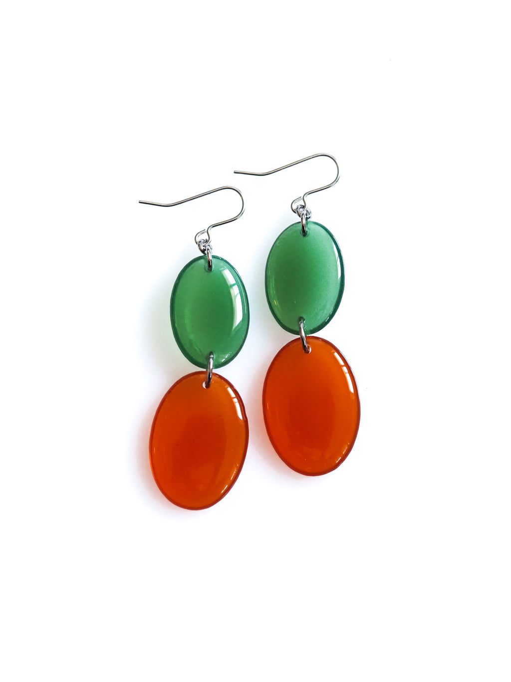 Duet resin drop earrings from the Chroma collection in transparent forest green and rust on a white background
