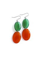 Duet resin drop earrings from the Chroma collection in transparent forest green and rust on a white background