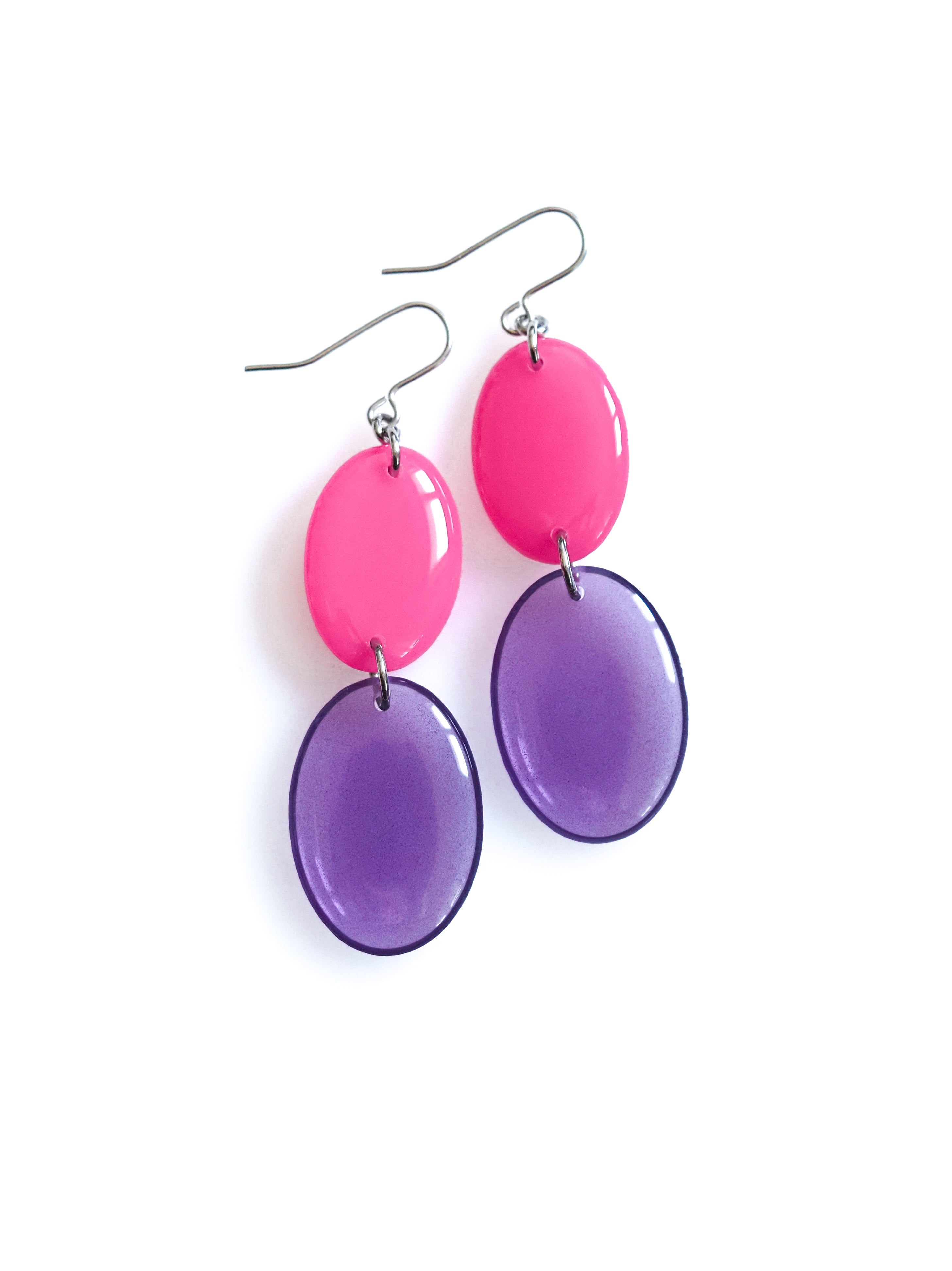 Duet resin drop earrings from the Chroma collection in candy pink and transparent aubergine on a white background