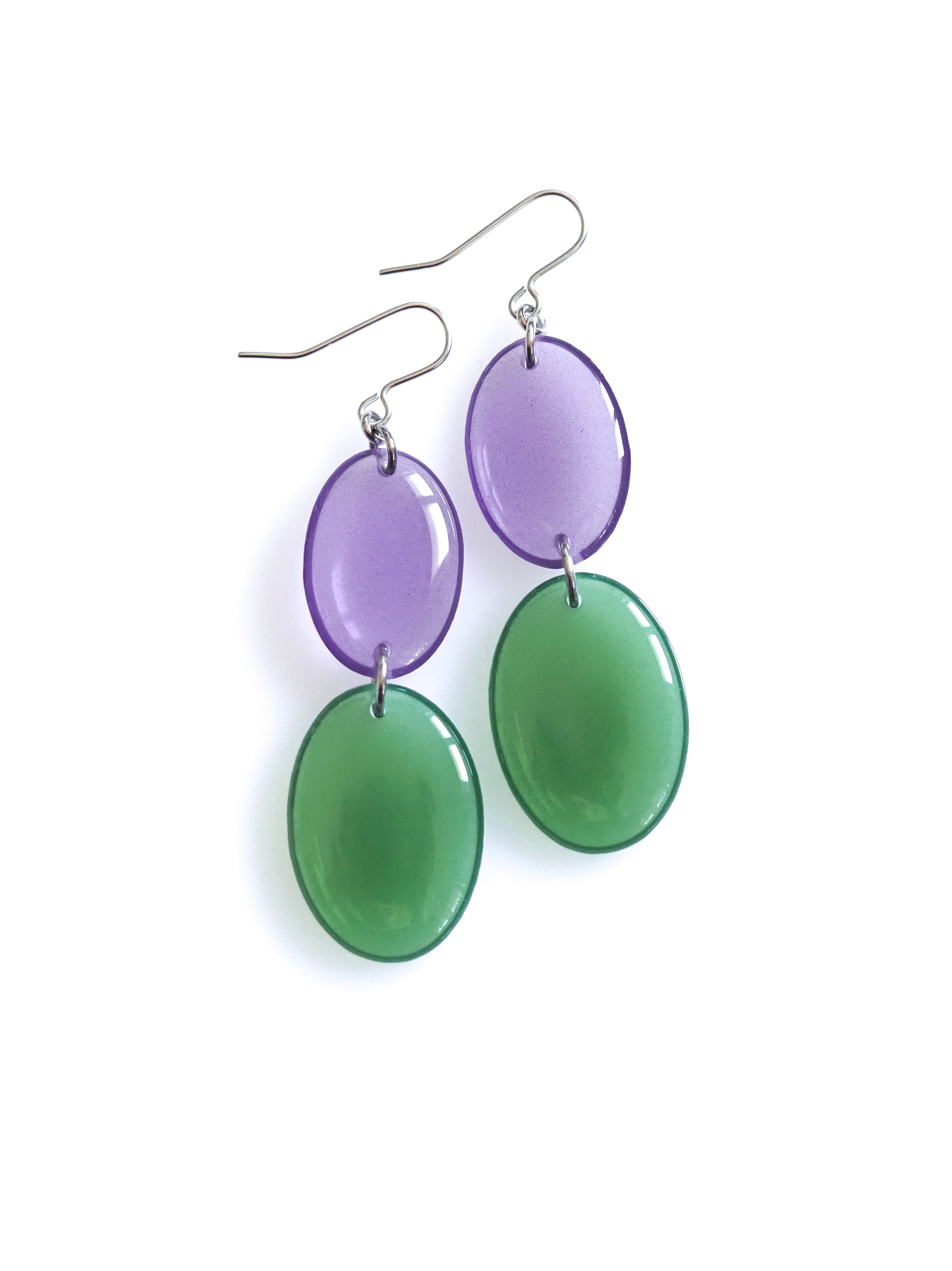 Duet resin drop earrings from the Chroma collection in transparent aubergine and transparent forest green on a white background