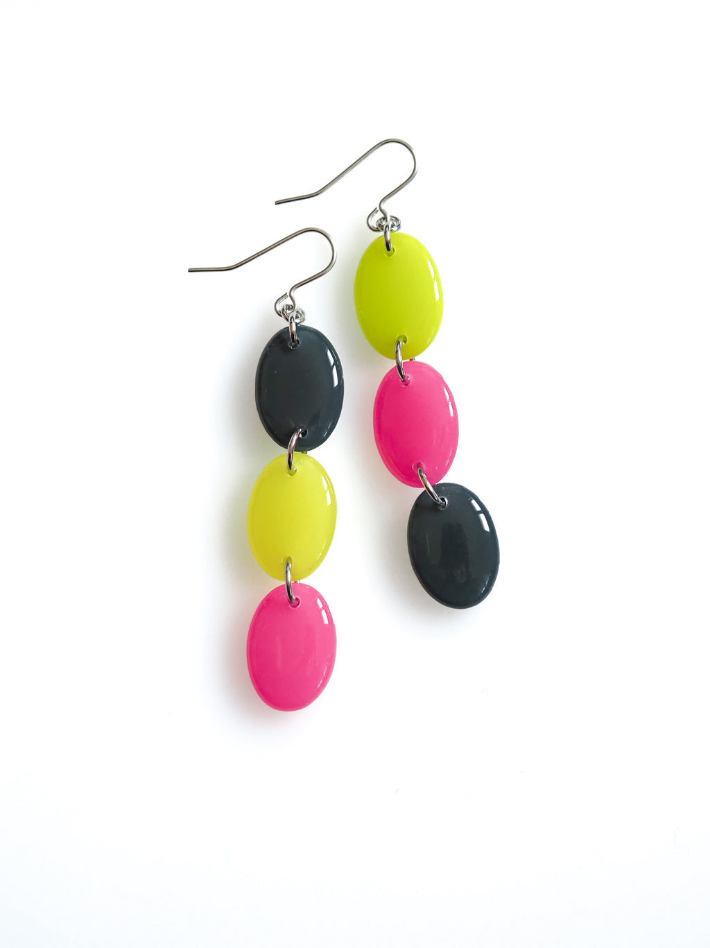 Sequence resin drop earrings from the Chroma collection in petrol grey, electric lichen and candy pink on a white background