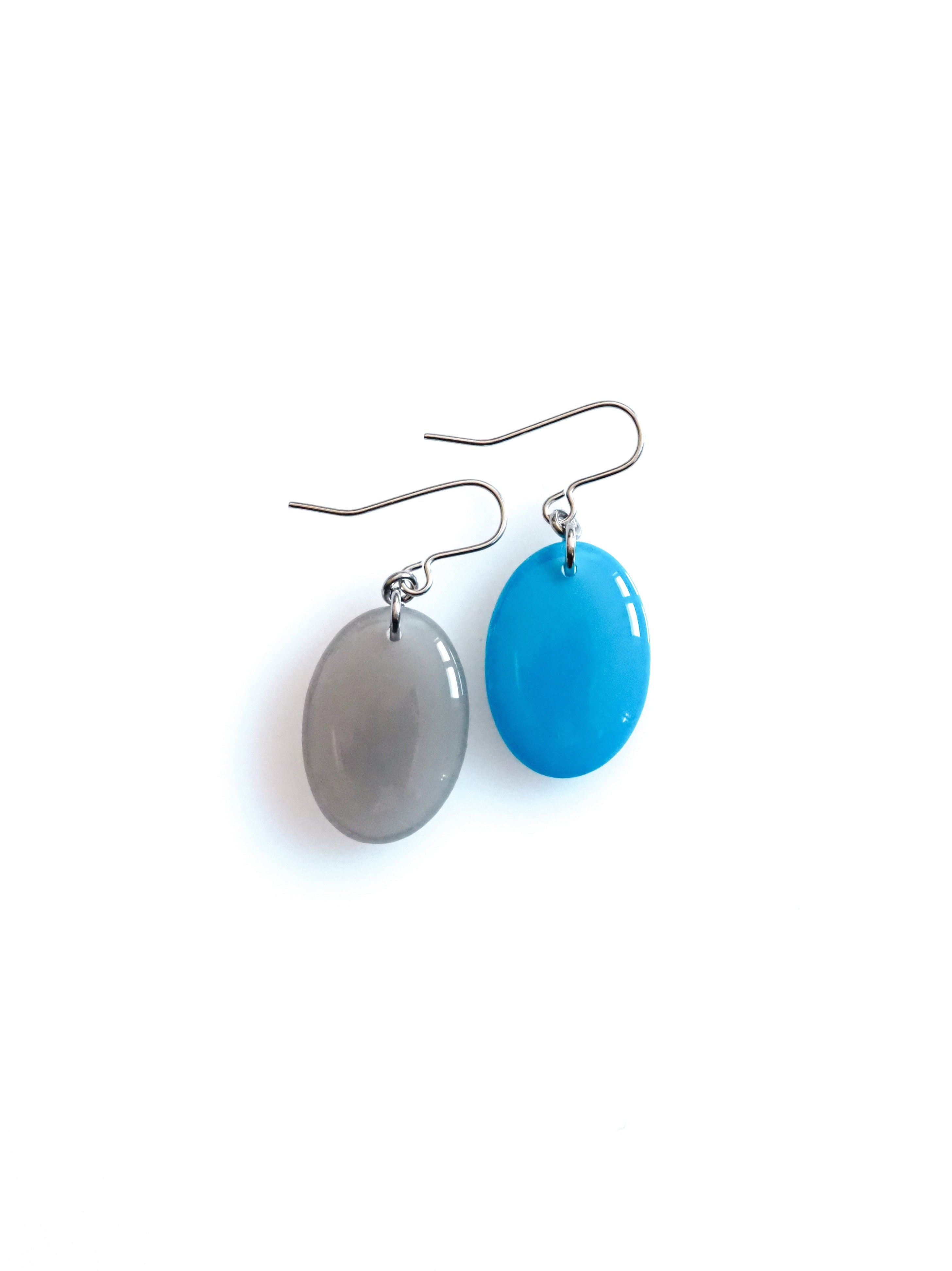 Solo resin drop earrings from the Chroma collection in mist grey and bright blue on a white background