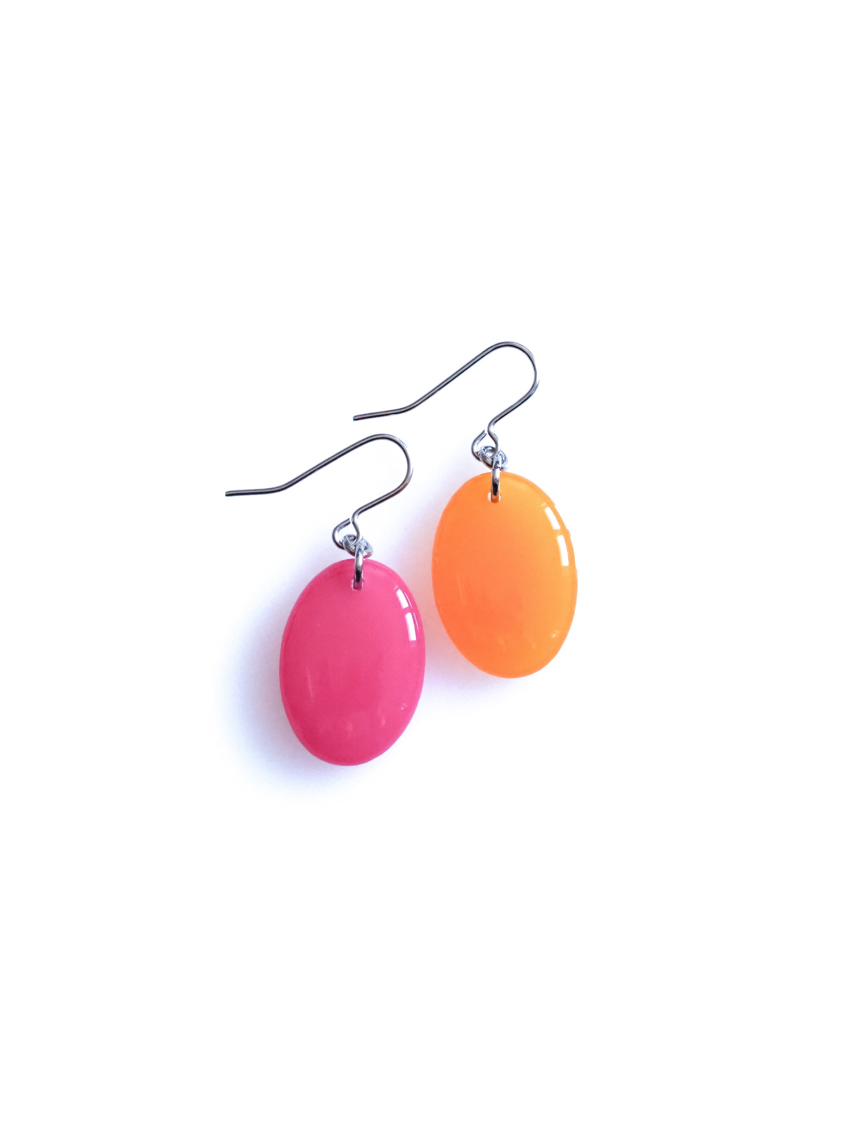 Solo resin drop earrings from the Chroma collection in candy pink and translucent orange on a white background