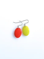 Solo resin drop earrings from the Chroma collection in red and electric lichen on a white background