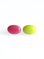 Solo resin stud earrings from the Chroma collection in candy pink and electric lichen on a white background