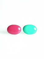 Solo resin stud earrings from the Chroma collection in candy pink and turquoise on a white background