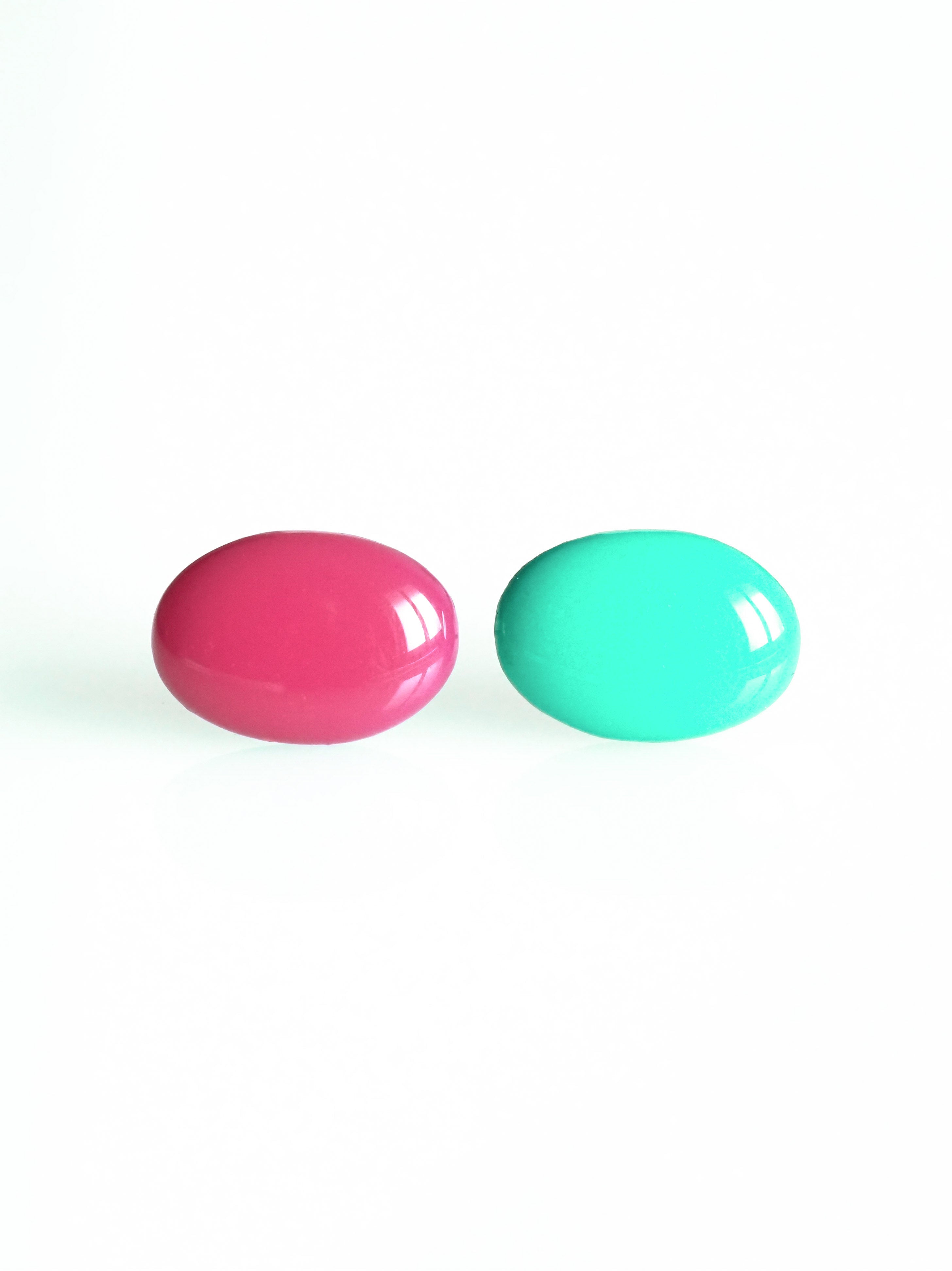Solo resin stud earrings from the Chroma collection in candy pink and turquoise on a white background