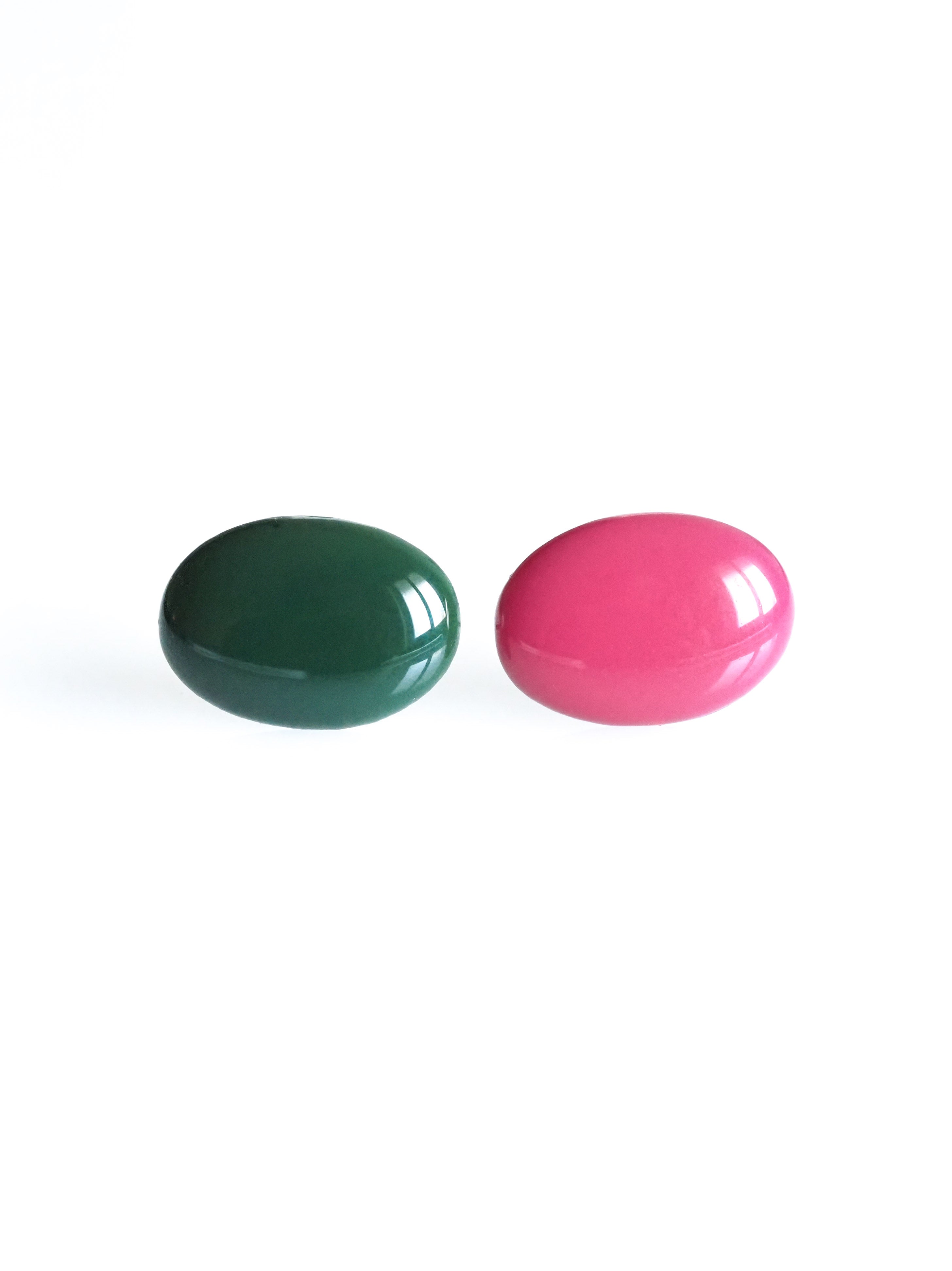 Solo resin stud earrings from the Chroma collection in forest green and candy pink on a white background