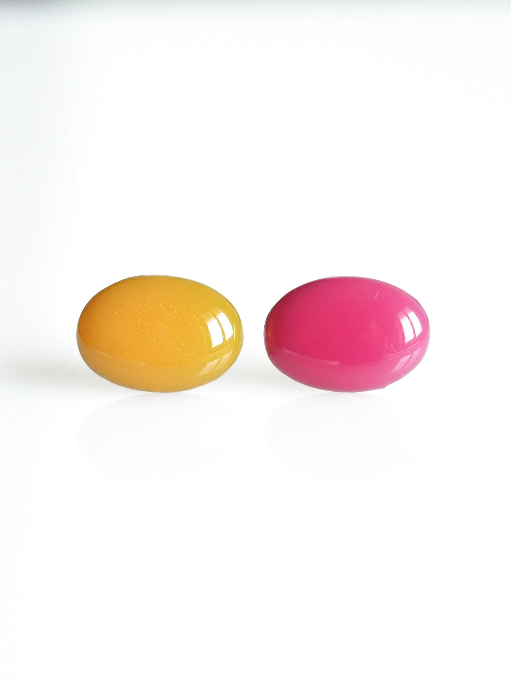 Solo resin stud earrings from the Chroma collection in marigold yellow and candy pink on a white background