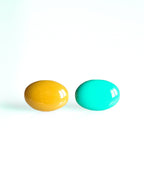 Solo resin stud earrings from the Chroma collection in marigold yellow and turquoise on a white background