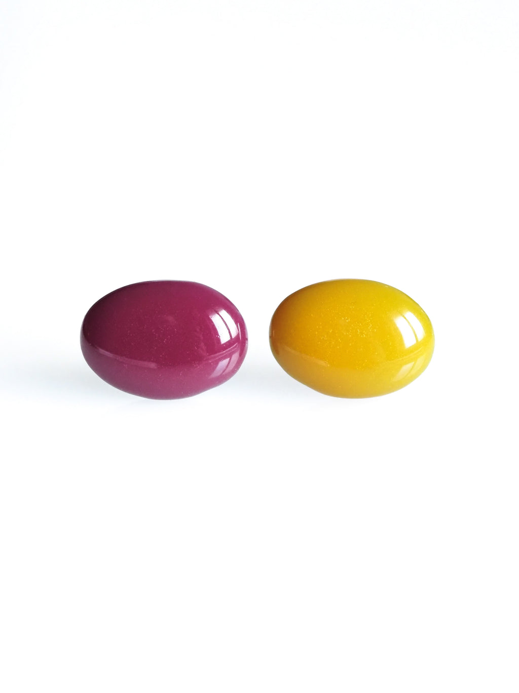 Solo resin stud earrings from the Chroma collection in mulberry and marigold yellow on a white background