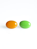 Solo resin stud earrings from the Chroma collection in orange and grass green on a white background