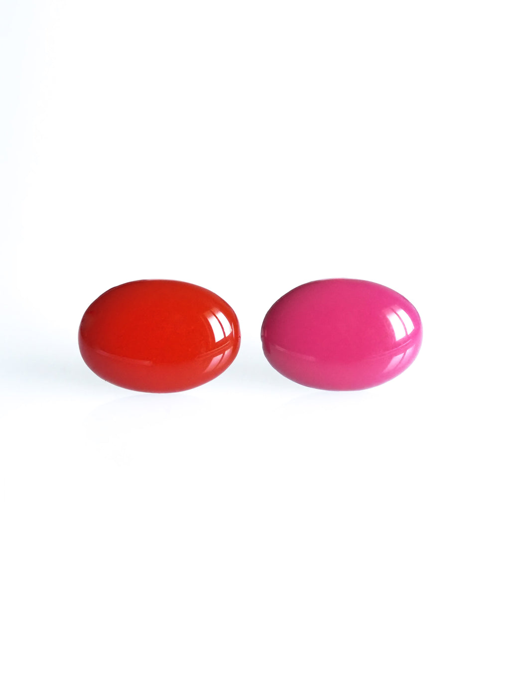 Solo resin stud earrings from the Chroma collection in red and candy pink on a white background