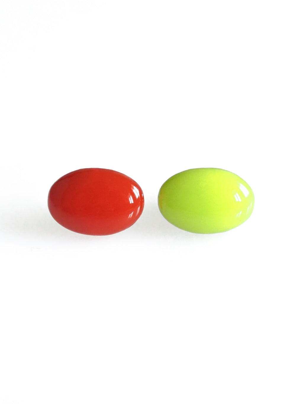 Solo resin stud earrings from the Chroma collection in red and electric lichen on a white background